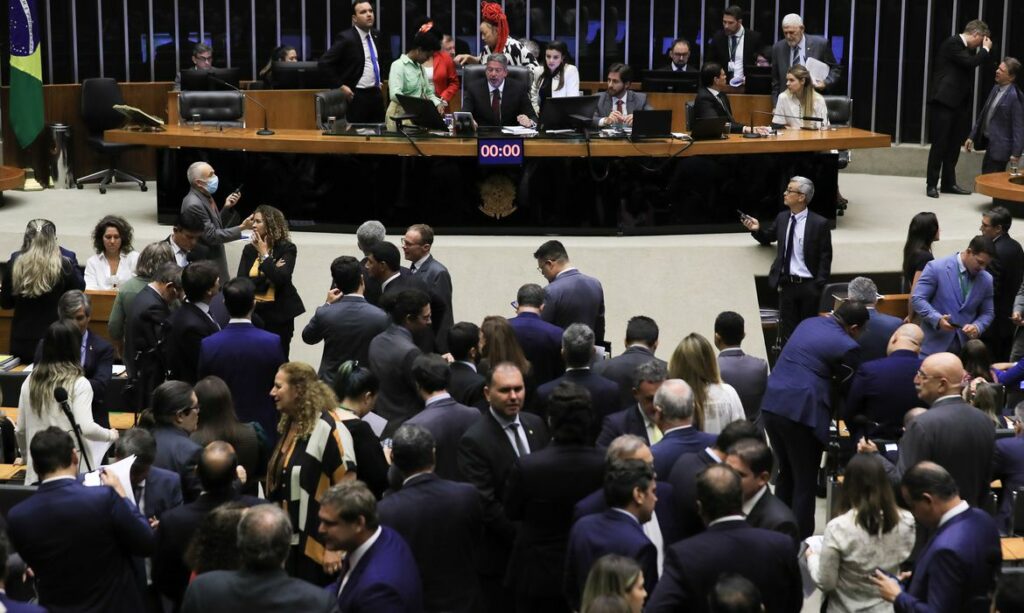 Imagem do plenário da Câmara, lotado de parlamentares, a maioria em pé, durante a votação.